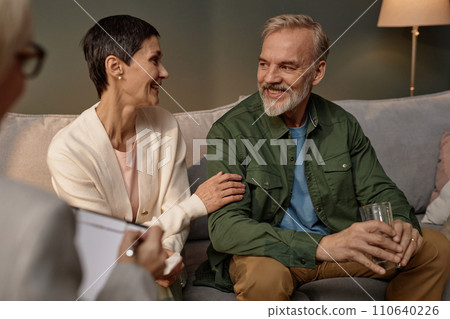 Portrait of mature adult couple smiling happily in successful couples therapy session Portrait of mature adult couple smiling happily in successful couples therapy session 110640226