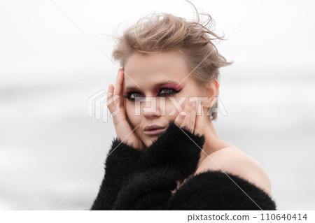 Blonde woman posing outside on white natural background and bright makeup really makes her stand out 110640414