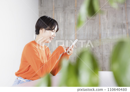 A woman operating a smartphone A woman operating a smartphone 110640480