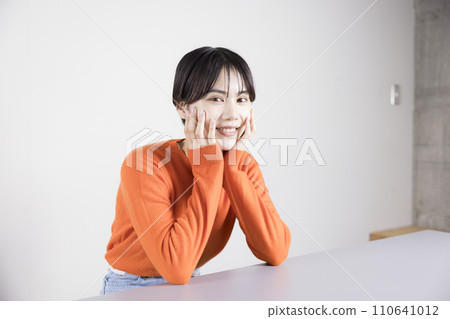 微笑的年輕女子將下巴靠在背上 110641012