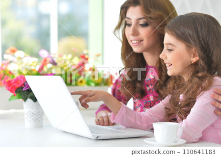 Portrait of Mother and daughter using laptop Portrait of Mother and daughter using laptop 110641183