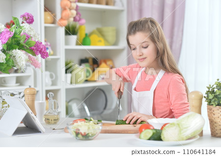 Portrait of young girl cooking in kitchen Portrait of young girl cooking in kitchen 110641184