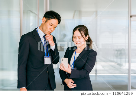 Businessman and businesswoman thinking while looking at their smartphones (stress, worries, troubles, problems) 110641299