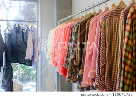 Apparel shop, clothes made of colorful fabrics on hangers Apparel shop, clothes made of colorful fabrics on hangers 110641722