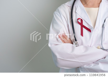 Doctor with Burgundy Red Ribbon for March multiple myeloma Cancer and December World Aids Day Awareness month. Healthcare and world cancer day concept Doctor with Burgundy Red Ribbon for March multiple myeloma Cancer and December World Aids Day Awareness month. Healthcare and world cancer day concept 110641956