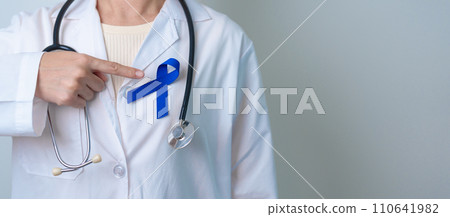 March Colorectal Cancer Awareness month, doctor with dark Blue Ribbon for supporting people living and illness. Healthcare, hope and World cancer day concept 110641982