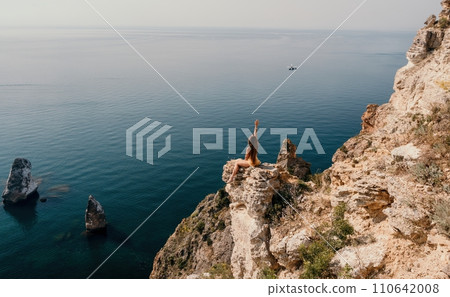 Woman travel sea. Happy tourist enjoy taking picture outdoors for memories. Woman traveler looks at the edge of the cliff on the sea bay of mountains, sharing travel adventure journey 110642008