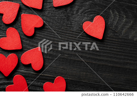 Red wooden hearts on black wooden background Red wooden hearts on black wooden background 110642666