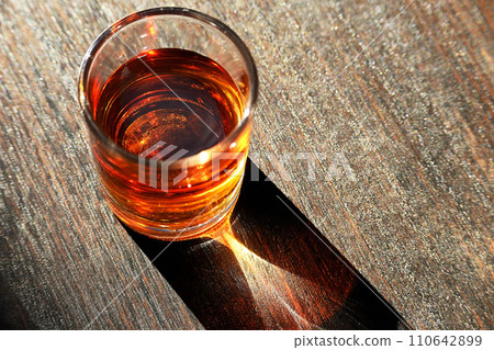 Liquor poured into a shot glass Liquor poured into a shot glass 110642899