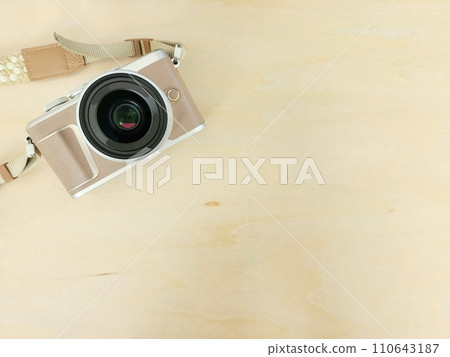 A mirrorless single-lens camera placed on a wooden table A mirrorless single-lens camera placed on a wooden table 110643187