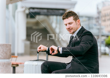 外國商人在出差或旅行時在公車站、計程車站或等候區檢查時間 外國商人在出差或旅行時在公車站、計程車站或等候區檢查時間 110643306