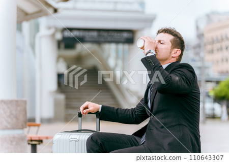 外國商人在出差或旅行時在公車站、計程車站或等候區喝咖啡 外國商人在出差或旅行時在公車站、計程車站或等候區喝咖啡 110643307