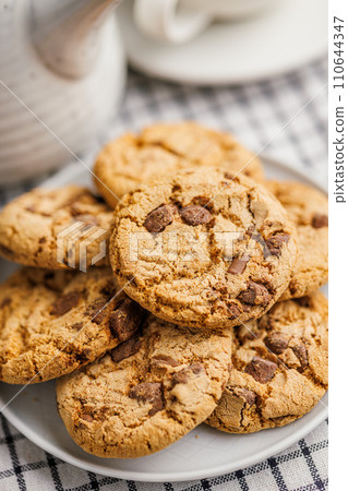 Sweet chocolate cookies on plate on checkered napkin. 110644347