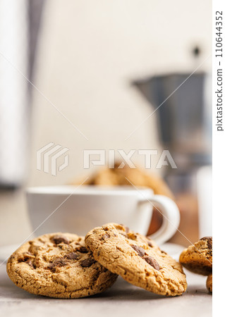 Sweet chocolate cookies and coffee cup on kitchen table. Sweet chocolate cookies and coffee cup on kitchen table. 110644352