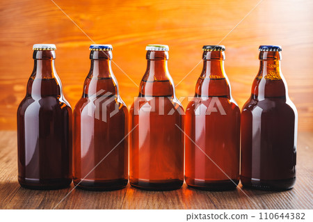 Bottles of beer on wooden table. Bottles of beer on wooden table. 110644382