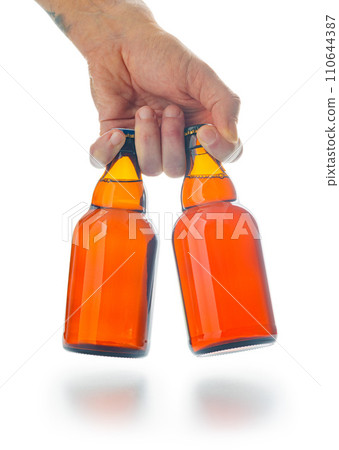 Bottles of beer in hand  isolated on white background. 110644387