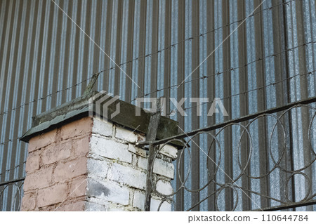Barbed wire on a high fence closeup 110644784