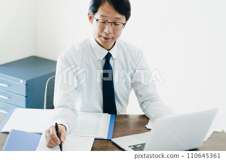 Hand of a male businessman checking the ledger 110645361
