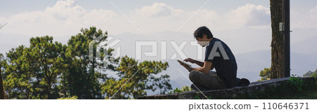 landscape and travel concept with solo freelancer man sit on wooden and use tablet work from outdoor with layer of mountain background 110646371