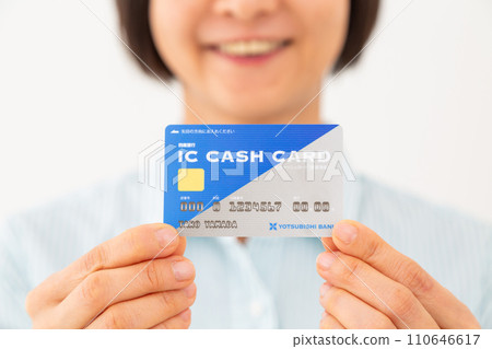 Smiling middle-aged woman holding a bank IC cash card Smiling middle-aged woman holding a bank IC cash card 110646617