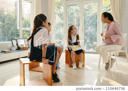 Group of kids repeating after teacher when reading letter on card Group of kids repeating after teacher when reading letter on card 110646736