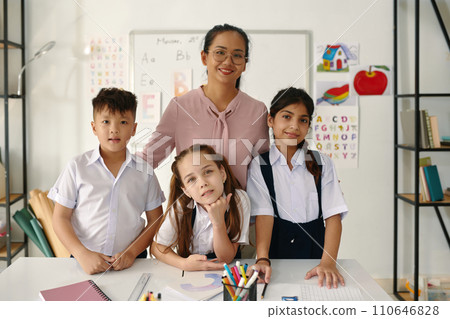 Happy teacher and kids standing in classroom 110646828