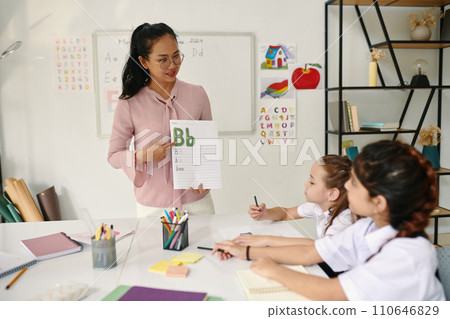 Teacher showing kids letter of English alphabet 110646829