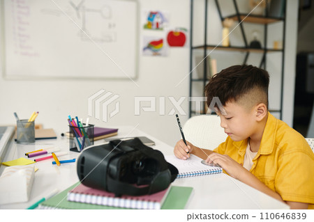 Creative boy drawing in textbook in class 110646839