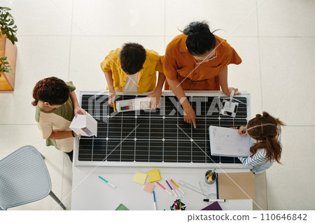 Teacher and schoolkids discussing solar energy and sustainability living, top view 110646842