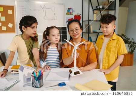 Smiling teacher explaining kids wind turbine working principle 110646855