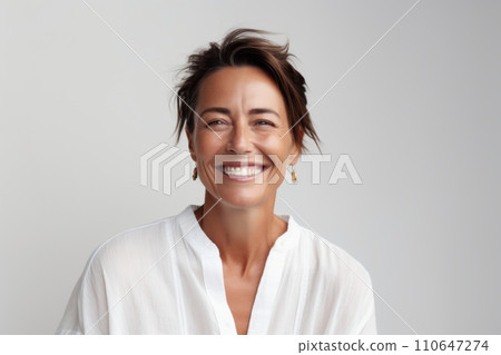 Portrait of a happy young woman smiling at camera against grey background. Portrait of a happy young woman smiling at camera against grey background. 110647274