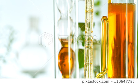 Getting natural oil from natural substances and flowers. Yellow oil flows in a spiral. 110647785