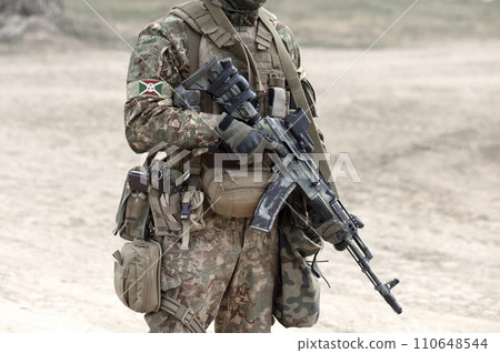 Soldier with assault rifle and flag of Burundi on military uniform. Collage. Soldier with assault rifle and flag of Burundi on military uniform. Collage. 110648544