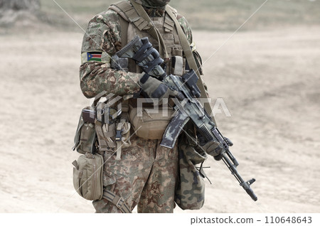 Soldier with assault rifle and flag of South Sudan on military uniform. Collage. 110648643