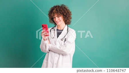 Happy young woman doctor checking smartphone Happy young woman doctor checking smartphone 110648747