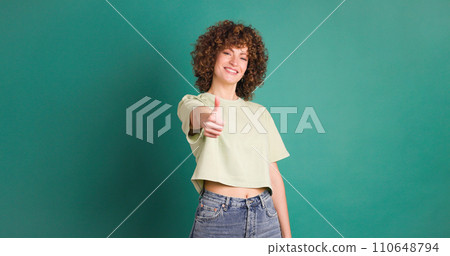 Adult woman on studio giving a thumbs up gesture 110648794