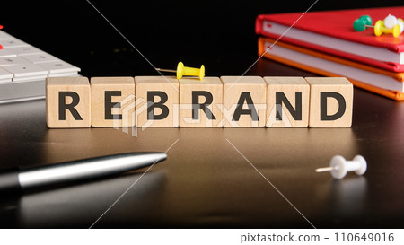 REBRAND the text of non-wooden cubes next to notepads, a calculator, a pen on a black background REBRAND the text of non-wooden cubes next to notepads, a calculator, a pen on a black background 110649016