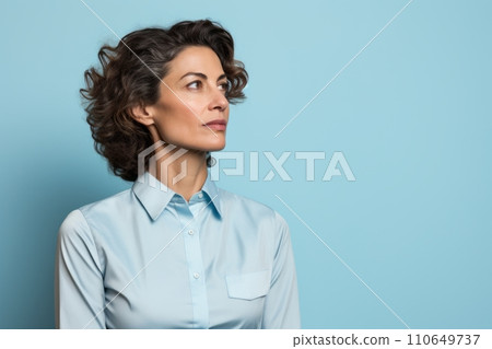 Side view of thoughtful businesswoman looking away while standing against blue background. 110649737