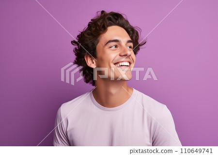 Portrait of happy young man with curly hair, isolated on purple background. 110649741