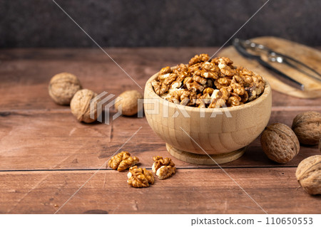 Walnuts in a wooden bowl. Shelled, dried seeds of walnuts in wooden bowl. Copy space. Walnuts in a wooden bowl. Shelled, dried seeds of walnuts in wooden bowl. Copy space. 110650553