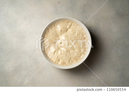 Top view sourdough starter in a bowl. Home baking, wild east, fermented food. 110650554