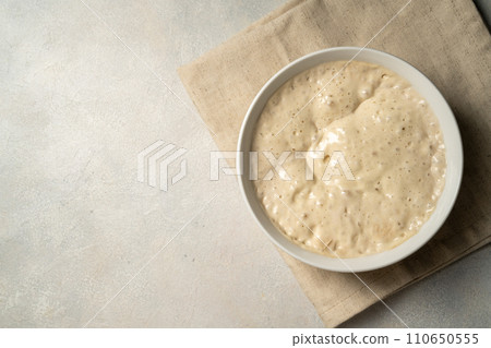Top view sourdough starter in a bowl. Copy space. Home baking, wild east, fermented food. Top view sourdough starter in a bowl. Copy space. Home baking, wild east, fermented food. 110650555