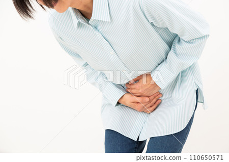 Middle-aged woman holding her lower abdomen 110650571