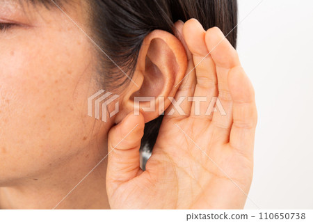 Middle-aged woman with hand on ear (hard of hearing) Middle-aged woman with hand on ear (hard of hearing) 110650738