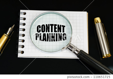 On a black surface there is a pen, a notebook and a magnifying glass. The inscription in the notebook - Content Planning On a black surface there is a pen, a notebook and a magnifying glass. The inscription in the notebook - Content Planning 110651725