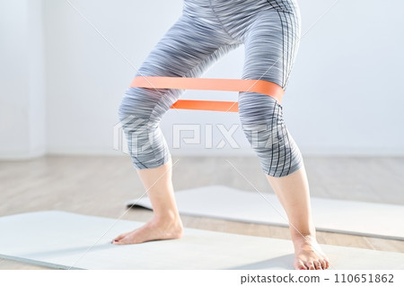一位女士使用阻力帶進行下半身訓練 一位女士使用阻力帶進行下半身訓練 110651862