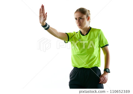 Young serious woman, soccer referee gesturing, raising hand forward meaning penalty kick against white studio background Young serious woman, soccer referee gesturing, raising hand forward meaning penalty kick against white studio background 110652389