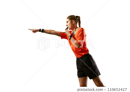 Young woman, football referee in uniform pointing and blowing whistle, controlling game rules against white studio background Young woman, football referee in uniform pointing and blowing whistle, controlling game rules against white studio background 110652427