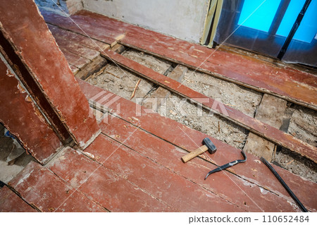 Old wooden floor repairing. Old planks on the floor. 110652484