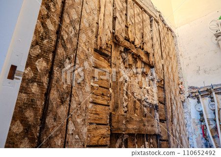 Old wooden wall damaged by termites. Close-up view. Rotten wall. Real photo. Side view. Old wooden wall damaged by termites. Close-up view. Rotten wall. Real photo. Side view. 110652492
